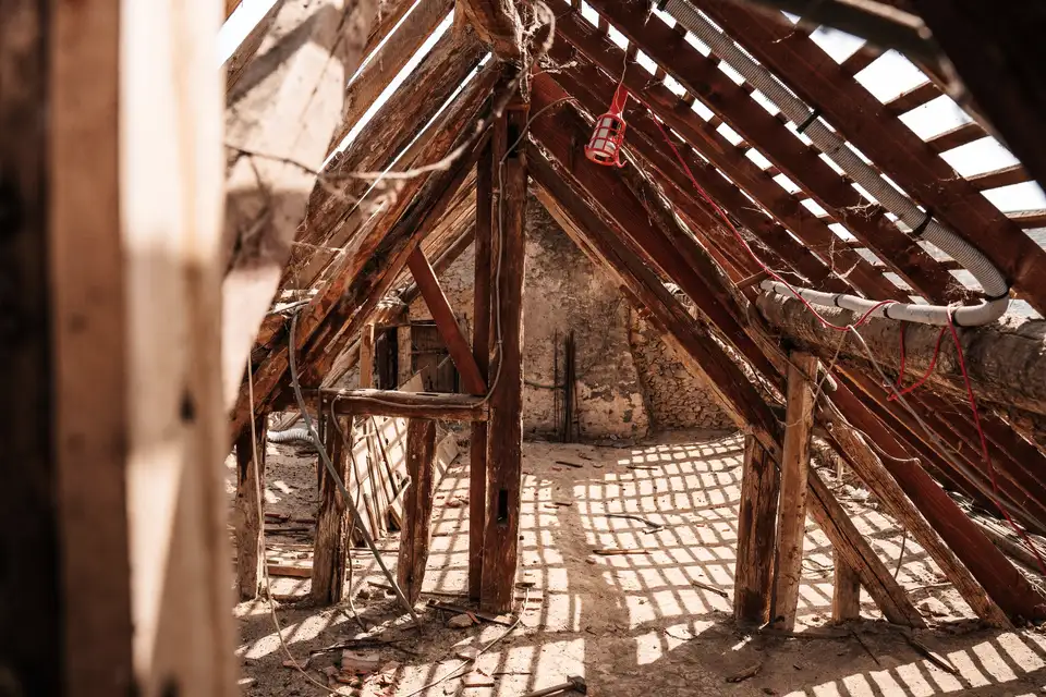 Inside an attic, looking along the rafters and roof boards